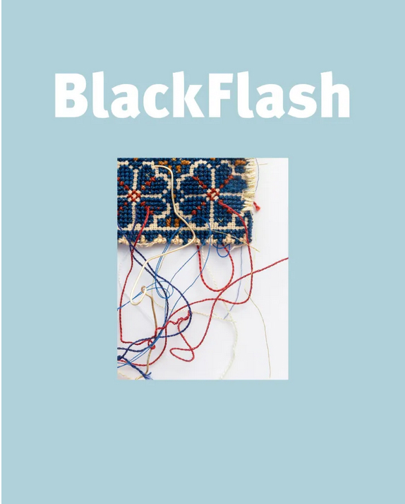The front cover of a magazine in solid light-baby blue with an image at the center. Title of the magazine “BlackFlash” is in white letters in a plain, bold font. Image at the center has a white foreground and has Palestinian embroidery in the top left corner with threads extending from the edge of the piece. Embroidery has floral patterns in red and dark blue with some orange accents.  The piece is by Palestinian artist Samar Hejazi