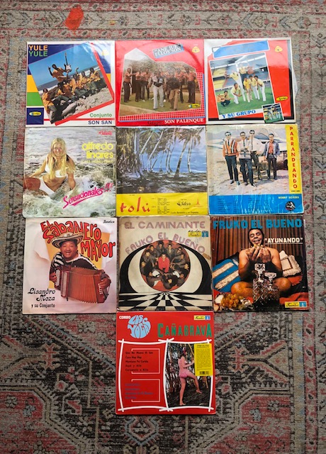 A selection brightly colored records on a patterned rug. 